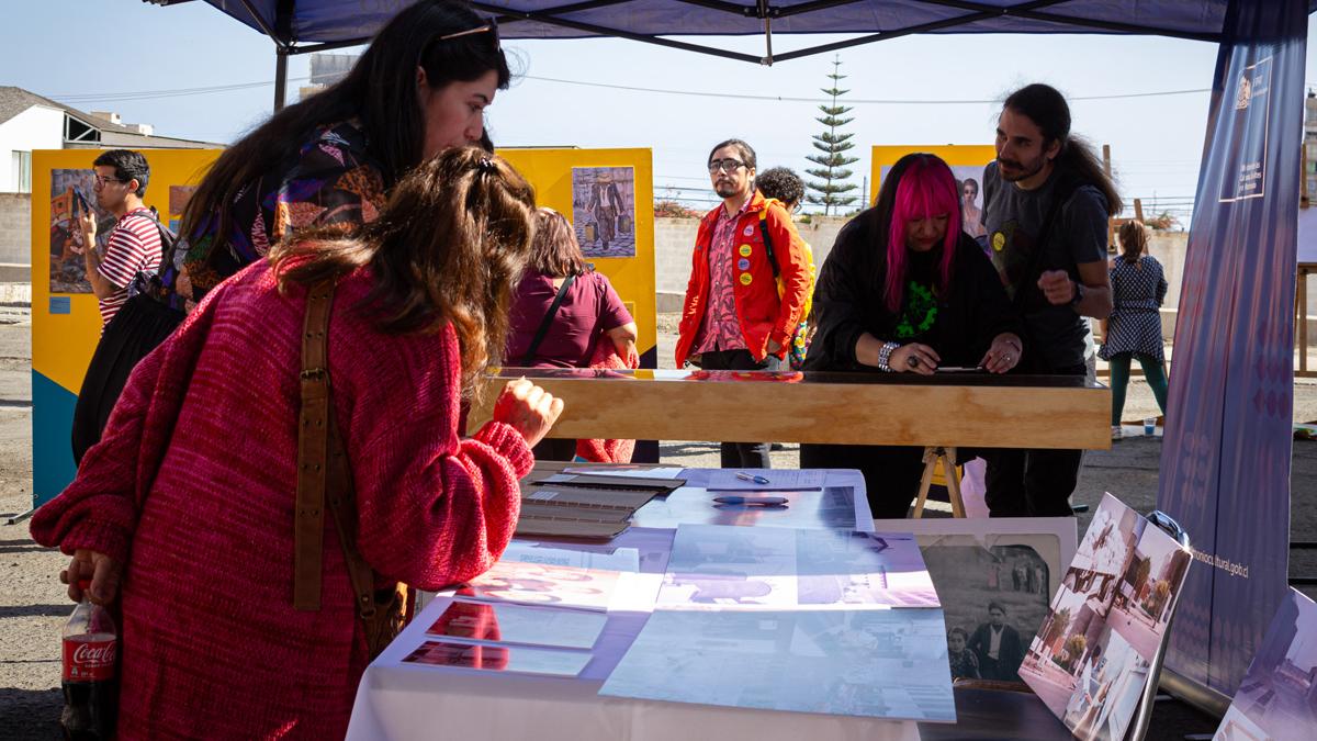 personas mirando documentos ubicados en una mesa.