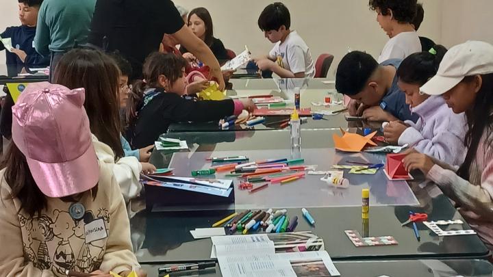 Niños y niñas en taller de origami.