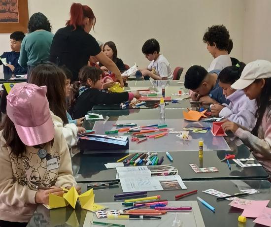 Niños y niñas en taller de origami.